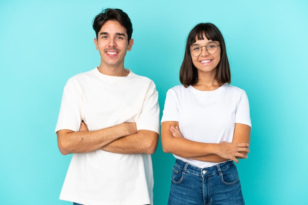 Photo young mixed race couple isolated on blue background keeping the arms crossed in frontal position