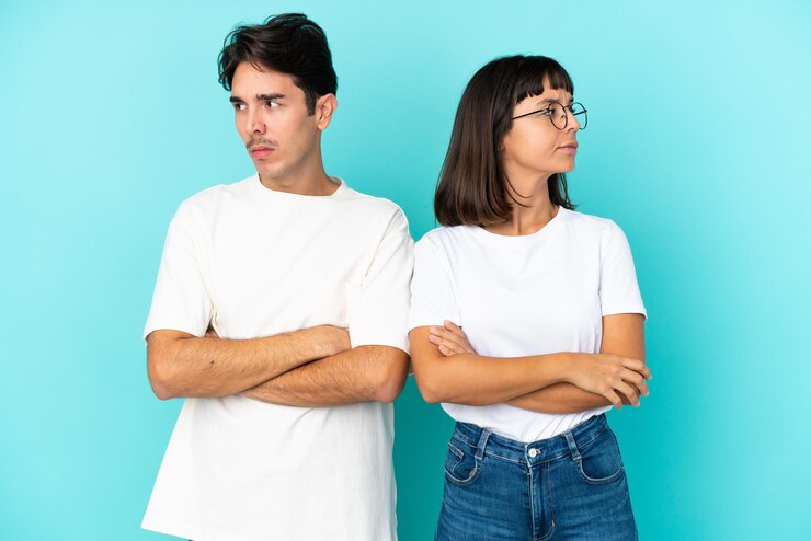 Photo young mixed race couple isolated on blue background with confuse face expression while bites lip