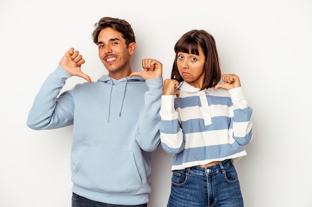 Young mixed race couple isolated on white background feels proud and self confident, example to follow.