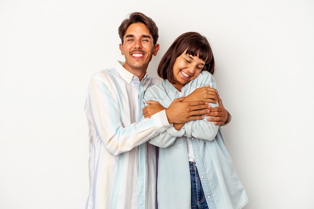 Young mixed race couple isolated on white background laughing and having fun.