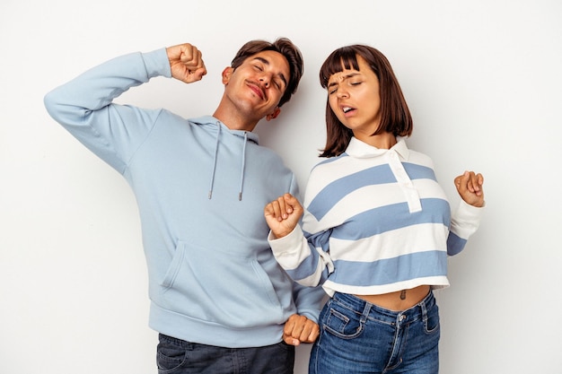 Young mixed race couple isolated on white background stretching arms, relaxed position.