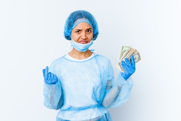 Молодая женщина-врач смешанной расы, держащая доллары, изолированные на белой стене