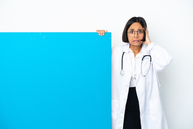 Young mixed race doctor woman with a big placard isolated on white background doing nervous gesture