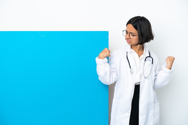 Молодая женщина-врач смешанной расы с большим плакатом на белом фоне делает сильный жест