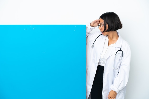 Photo young mixed race doctor woman with a big placard isolated on white background with surprise expression while looking side