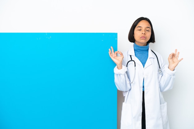 Young mixed race doctor woman with a big placard isolated on white background in zen pose