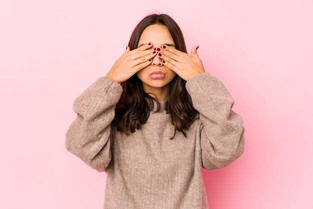 Young mixed race hispanic woman isolated afraid covering eyes with hands