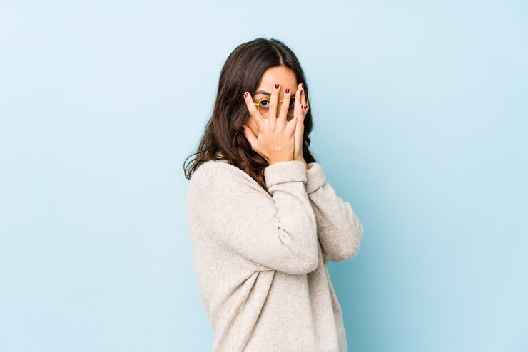 Photo young mixed race hispanic woman isolated blink through fingers frightened and nervous.