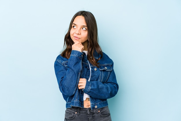 Young mixed race hispanic woman isolated looking sideways with doubtful and skeptical expression.