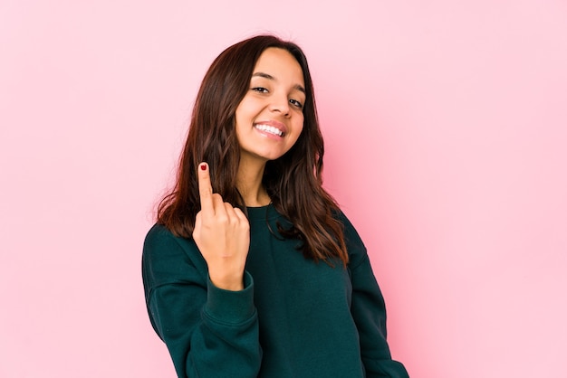 Young mixed race hispanic woman isolated pointing with finger at you as if inviting come closer.