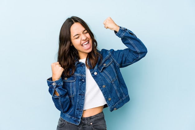 Young mixed race hispanic woman isolated raising fist after a victory, winner concept.