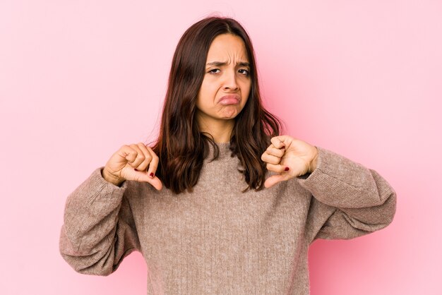 Young mixed race hispanic woman isolated showing thumb down, disappointment concept.