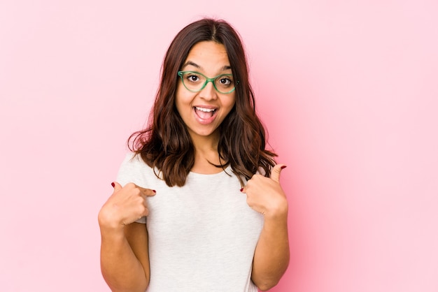 Young mixed race hispanic woman isolated surprised pointing with finger, smiling broadly.