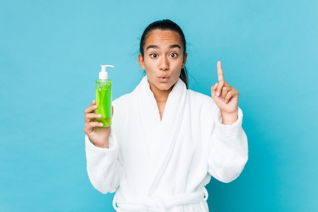 Young mixed race indian holding an aloe vera bottle having some great idea, concept of creativity.