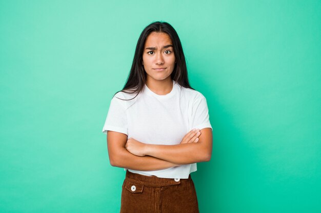 Young mixed race indian woman isolated unhappy looking with sarcastic expression.