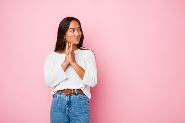 Young mixed race indian woman making up plan in mind, setting up an idea.