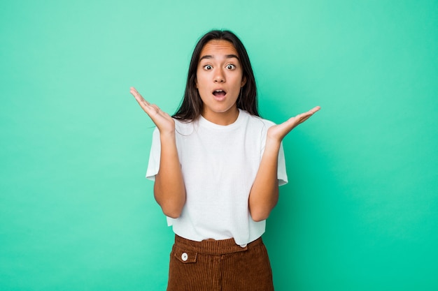 Young mixed race indian woman surprised and shocked.