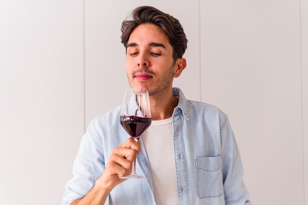 Young mixed race man drinking wine in a kitchen