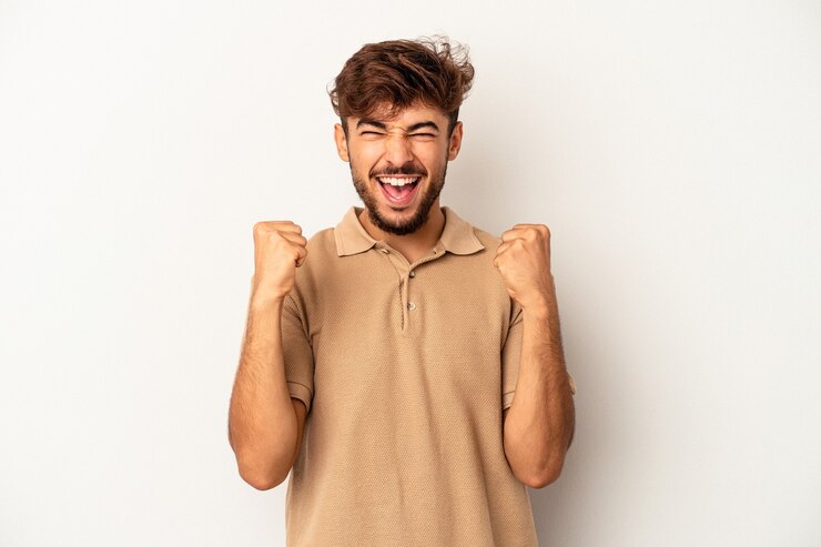 Photo young mixed race man isolated on grey background cheering carefree and excited. victory concept.