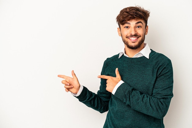 Young mixed race man isolated on grey background excited pointing with forefingers away.