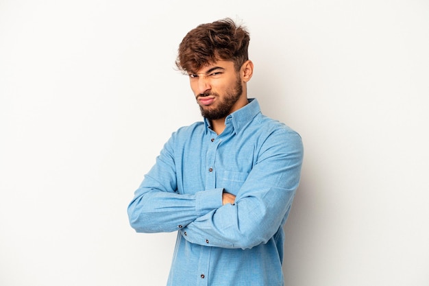 Young mixed race man isolated on grey background frowning face in displeasure, keeps arms folded.