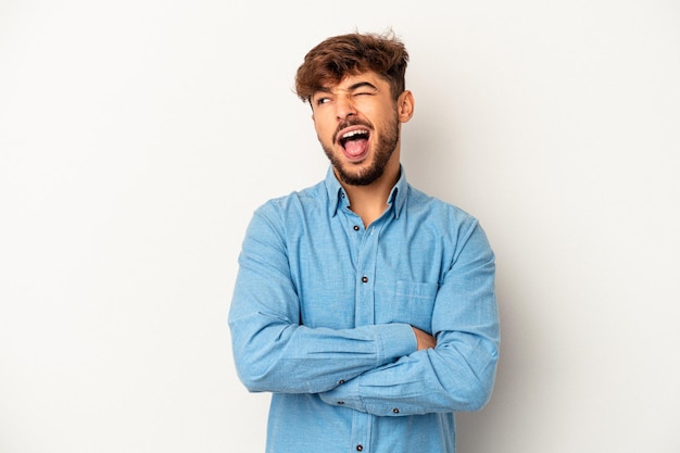 Young mixed race man isolated on grey background funny and friendly sticking out tongue.