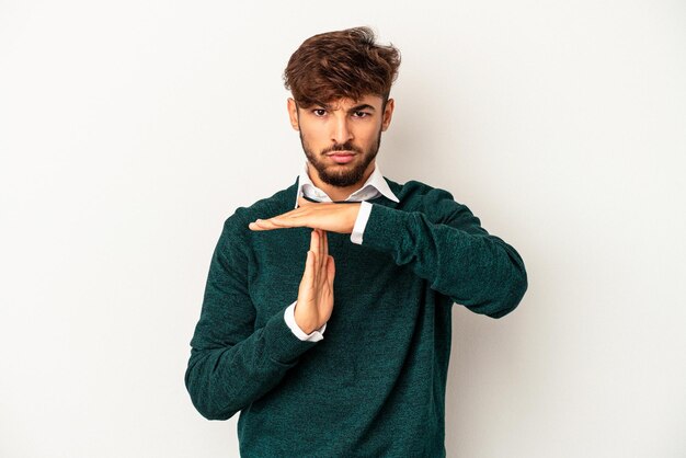 Young mixed race man isolated on grey background showing a timeout gesture.