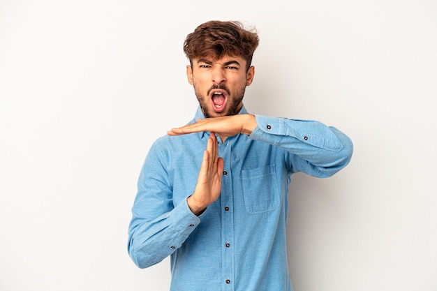 Young mixed race man isolated on grey background showing a timeout gesture.