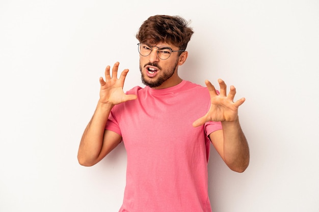 Young mixed race man isolated on grey background upset screaming with tense hands.