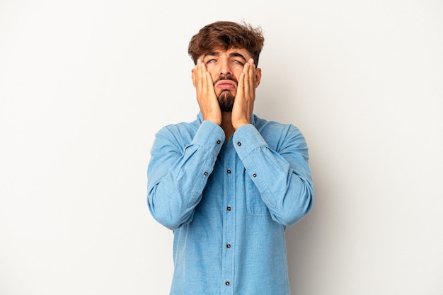 Young mixed race man isolated on grey background whining and crying disconsolately.