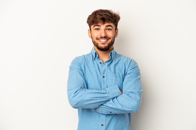 Young mixed race man isolated on grey background who feels confident, crossing arms with determination.