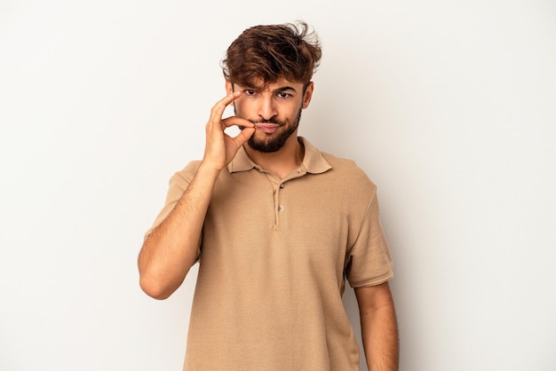 Young mixed race man isolated on grey background with fingers on lips keeping a secret.