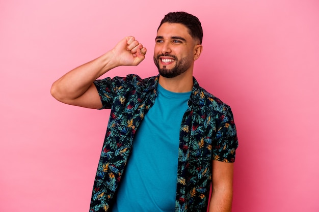 Young mixed race man isolated on pink background celebrating a victory, passion and enthusiasm, happy expression.