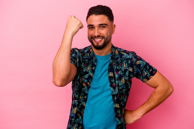 Young mixed race man isolated on pink background cheering carefree and excited. Victory concept.