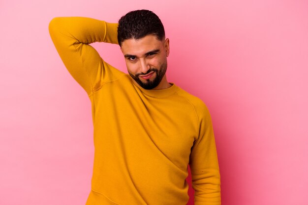 Young mixed race man isolated on pink background suffering neck pain due to sedentary lifestyle.