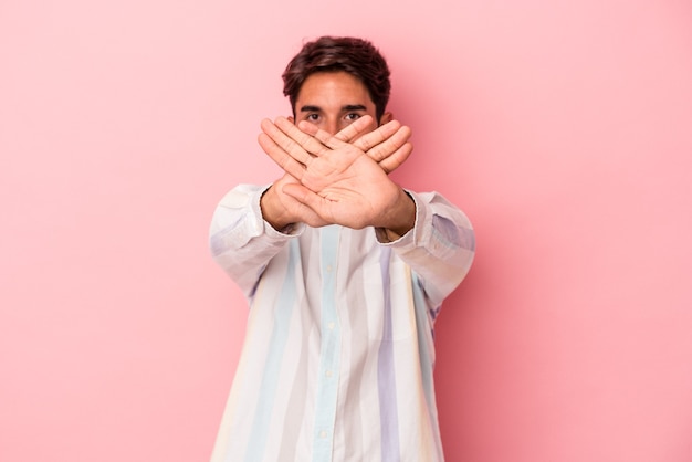 Young mixed race man isolated on white background doing a denial gesture