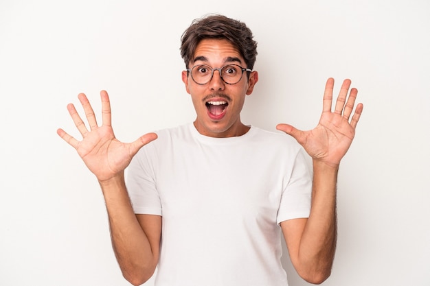 Young mixed race man isolated on white background receiving a pleasant surprise, excited and raising hands.