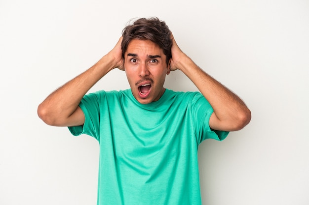 Young mixed race man isolated on white background screaming, very excited, passionate, satisfied with something.