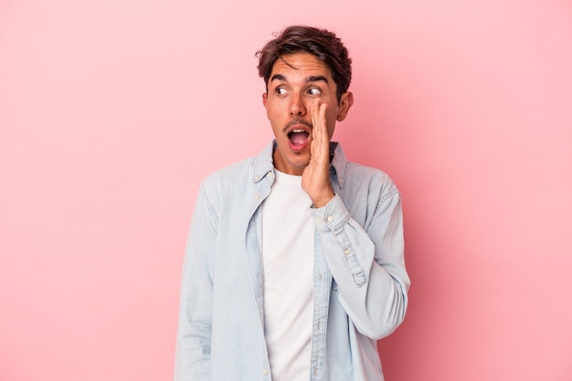 Young mixed race man isolated on white background shouting excited to front.