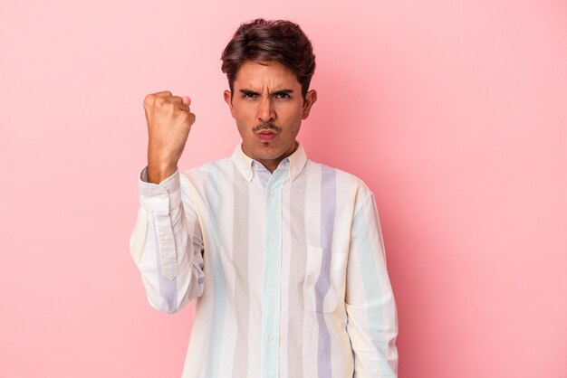 Young mixed race man isolated on white background showing fist to camera, aggressive facial expression.