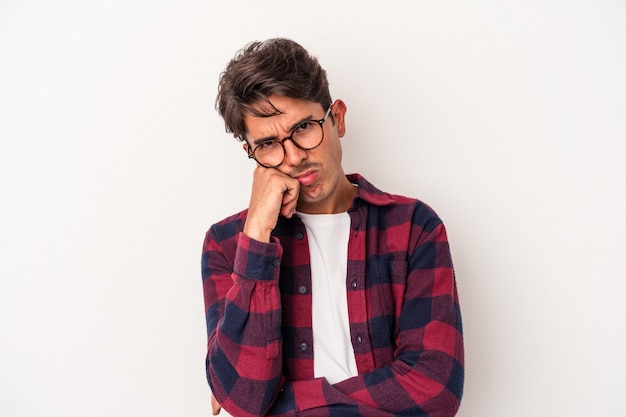 Young mixed race man isolated on white background tired of a repetitive task.