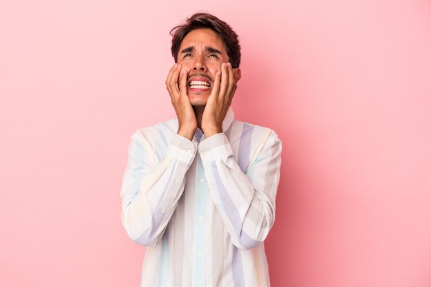 Young mixed race man isolated on white background whining and crying disconsolately.