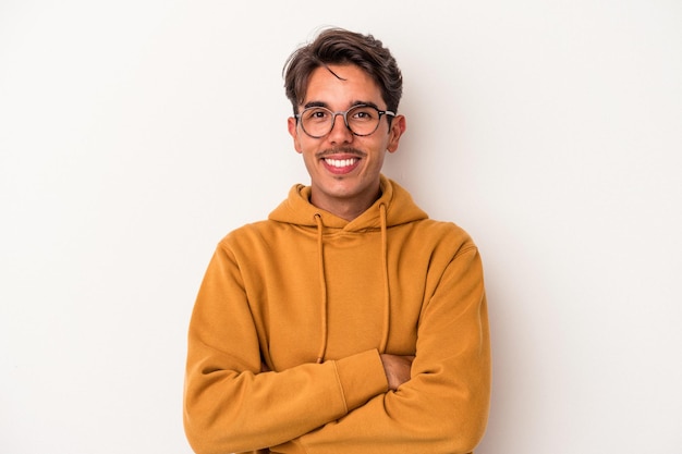 Young mixed race man isolated on white background who feels confident, crossing arms with determination.