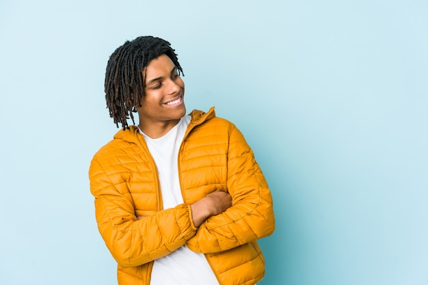 Young mixed race man smiling confident with crossed arms.