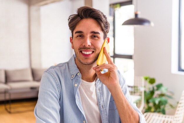 Young mixed race man talking on the phone in a kitchen