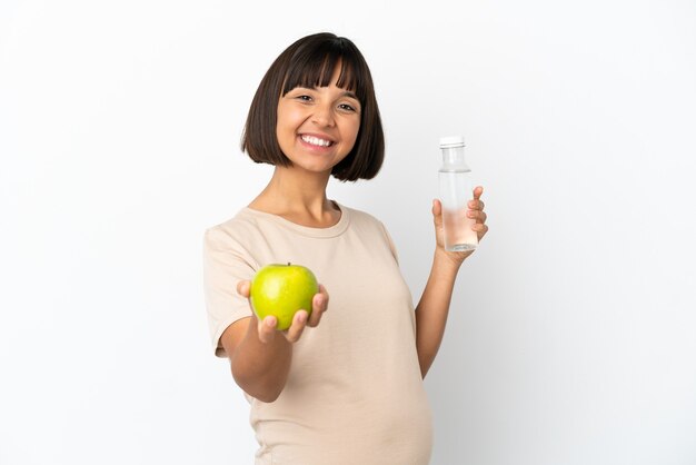사과와 물 한 병 흰색 배경에 고립 된 젊은 혼혈 임신 한 여자