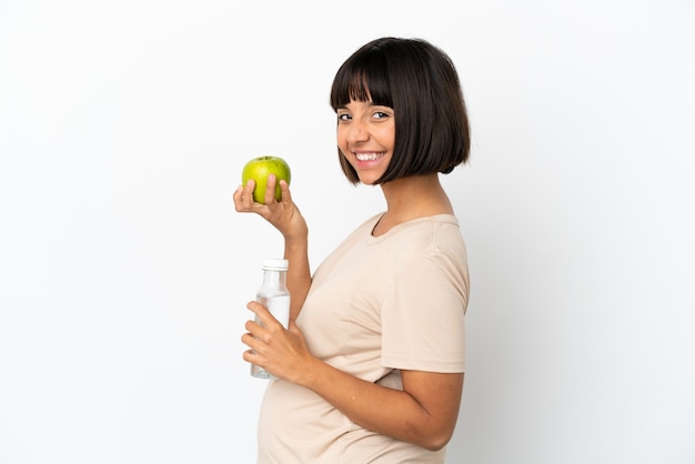 リンゴと水のボトルで白い背景で隔離の若い混血妊婦