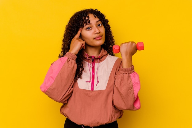 Young mixed race sport woman isolated on yellow