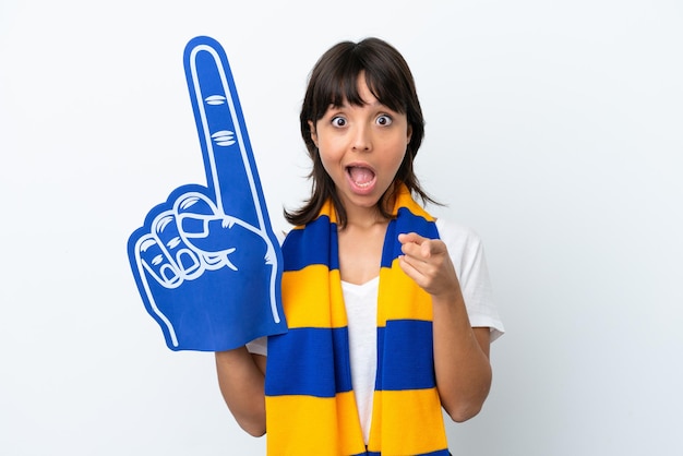 Young mixed race sports fan woman isolated on white background surprised and pointing front