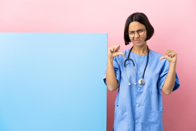 Young mixed race surgeon woman with a big banner isolated background laughing